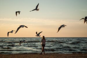 Woman alone at the beach- Nature promotes wellness.