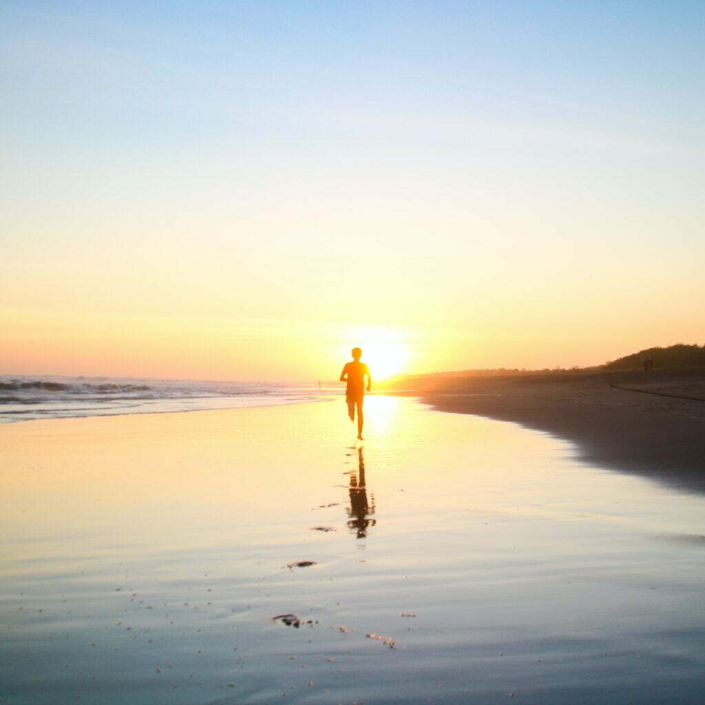 Man running on sunny beach-exercise boosts wellness!