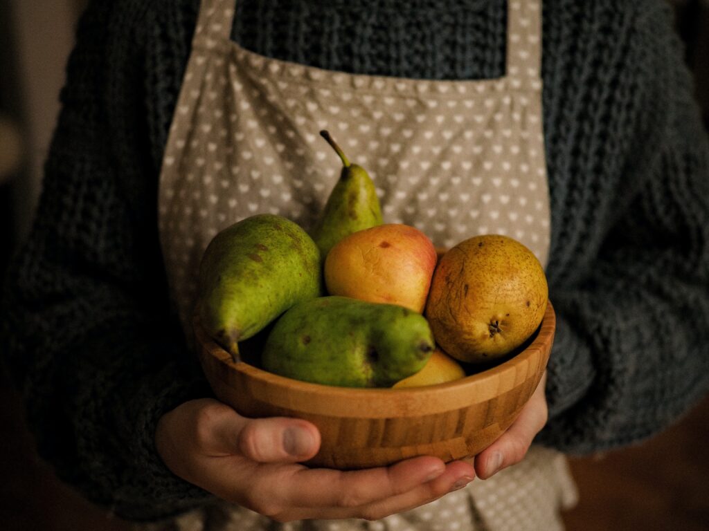 A woman holdins bowl of fruit symbolizes holistic nutrition.