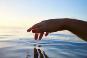 hand touching ocean
