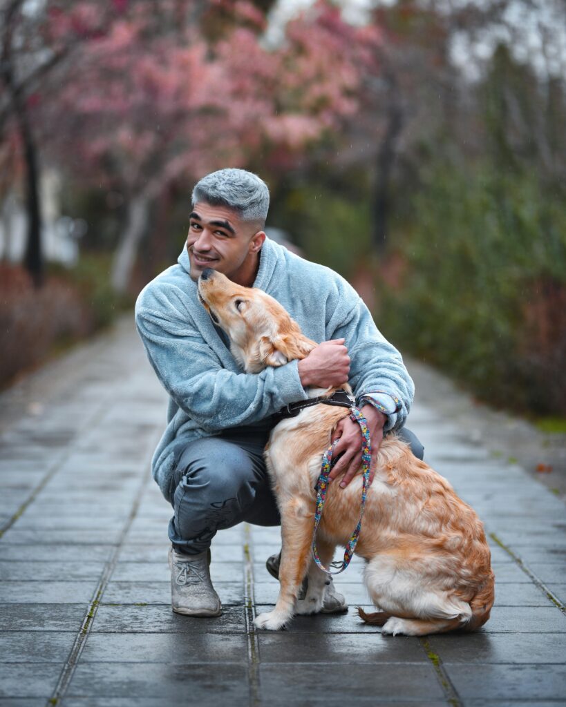 Man hugging a dog boosts Oxytocin and wellness.