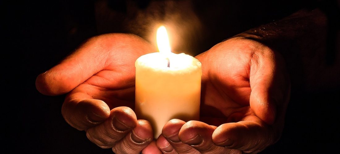 Open hands holding lit candle represents nurturing the inner light.